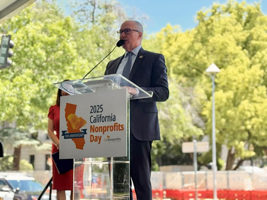 Asm. Hart at outdoors podium, speaking