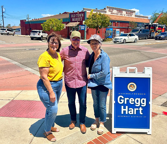 Asm. Hart with two constituents on sidewalk at intersection