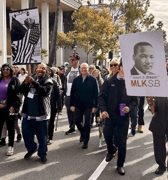 Asm. Hart marching with community members, some carrying signs of Dr. King