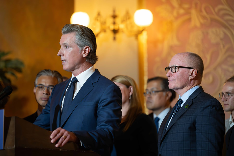 Go. Newsom at podium, speaking, with Asm. Hart at right side