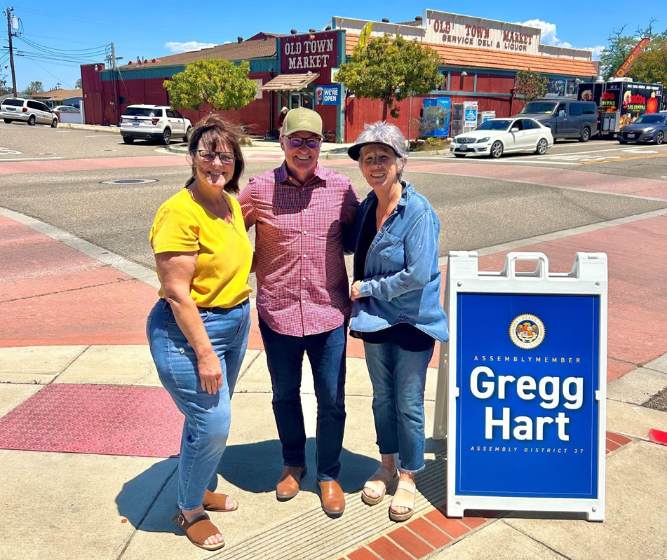 Asm. Bennet with two constituents on sidewalk at intersection